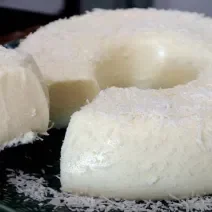 Foto em tons de branco da receita de gelado paulista servida em uma porção grande com uma fatia cortada