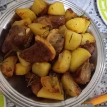 Foto da Receita de Costelinha de Porco com Batatas Salteadas no Alecrim. Observa-se um prato grande de servir de alumínio com as costelinhas e as batatas dispostas.