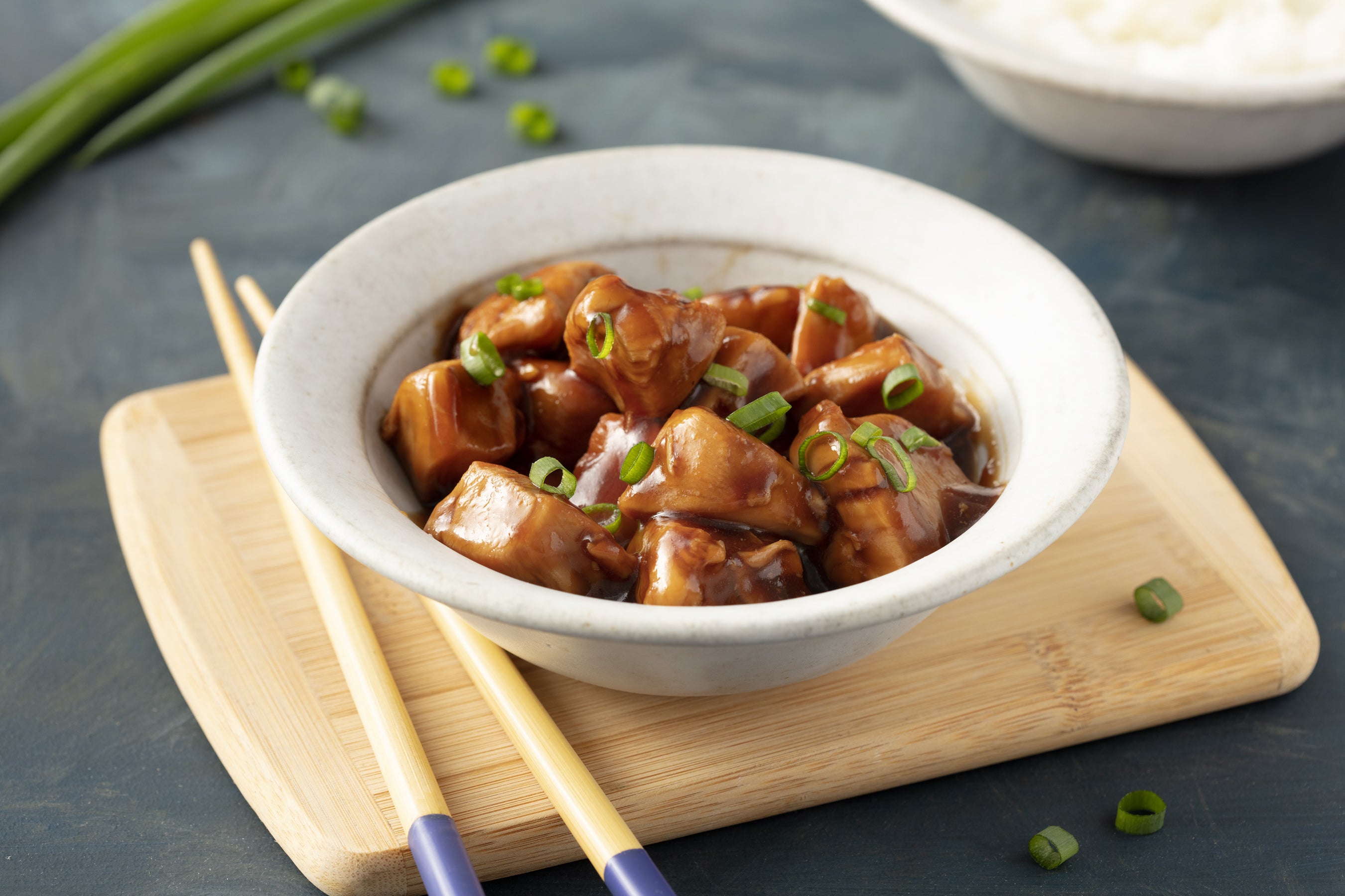 Frango de xadrez em prato verde sobre fundo de madeira - comida chinesa.