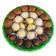 Um prato verde com diversos sabores de brigadeiros enrolados.