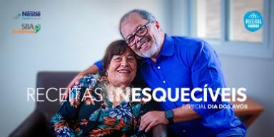 Receitas Inesquecíveis: Especial Dia dos Avós Fotografia de um homem e uma mulher, filho e mãe, um ao lado do outro, de mãos dadas em tom de carinho.
