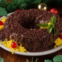 Receita de Brigadeirão de Natal, tradicional e delicioso, feito com Leite MOÇA, NESTLÉ Creme de Leite, Chocolate em Pó NESTLÉ CHOCOLATERIA, açúcar, ovos e margarina, decorado com fios de ovos, cerejas e sobre uma mesa de natal