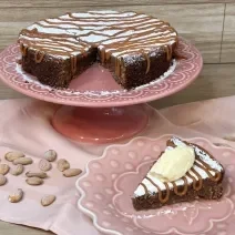 Fotografia em tons de rosa com uma toalha e um prato bailarina ao centro. Em cima do prato existe uma receita de torta italiana com recheio de chocolate e caramelo toffee