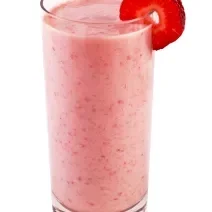 Fotografia de uma vitamina de de iogurte, leite, geleia de morango e Neston Cereais. A bebida está em um copo de vidro grande que tem uma rodela de morango na borda.