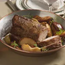 fotografia vista de cima de uma mesa, contém uma panela de inox com pedaços de carne dentro e pedaços de maçãs