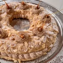 Foto da Receita de Paris Brest com Creme Mousseline, delicioso e impressionante, feito com uma base de massa choux tradicional e um recheio de creme mousseline com pasta de avelã, decorado com açúcar polvilhado e pontos e caramelo