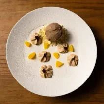 Receita de Café, Cardamomo e Laranja, delicioso e diferente, feito com Bolo de Amêndoa, Caramelo, Mousse de Laranja, Ganache Montada, Sorvete, Crumble Branco e decorado com Chocolate Branco