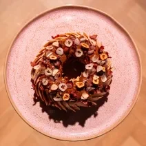 Foto vista de cima da receita de Paris Brest de Avelãs, uma receita rebuscada, repleta de uma decoração lindíssima com fatias de avelãs caramelizadas