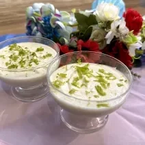 Fotografia em tons de rosa e azul com duas taças de vidro ao centro. Dentro da taça existe uma receita de mousse de limão com ASCENDA.