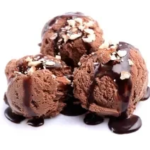 Fotografia de três bolas de sorvete de chocolate com cobertura de chocolate e farofa doce. A sobremesa está em um fundo branco.