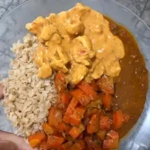 Fotografia em tons de amarelo em um prato redondo de vidro com o strogonoff de frango em cima e acompanhado de arroz integral.