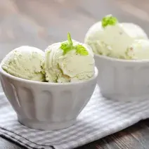 fotografia em tons de branco tirada de duas taças de sorvete brancas e ambas contém bolas de sorvete