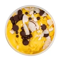 Fotografia vista de cima de um flan de maracujá, leite MOÇA e leite de coco, e por cima, gotinhas de chocolate e chips de coco. O creme está dentro de um recipiente de vidro na cor branco, sobre um fundo branco.