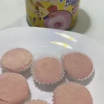 Fotografia de seis unidades de brigadeiro de nesquik em forminhas brancas, sobre um prato raso branco de vidro. Ao lado do prato tem uma embalagem de nesquik.