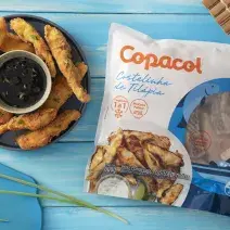 Foto da receita de Costelinha de Tilápia Copacol Empanada com Molho Oriental na Airfryer, servida em um tigela azul escura, com um pote pequeno com o molho no centro do prato, tudo numa bancada azul e com o pacote do produto Copacol