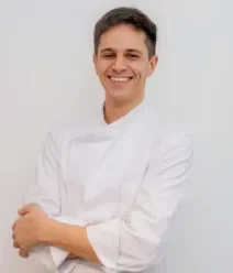 Fotografia mostra um chef de cozinha usando uma dolmã branca.