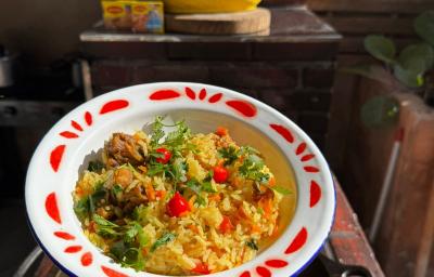 Fotografia mostra um prato com arrz amarelado, com pedaços de frango, cheiro-verde e pimenta biquinho. Fotografia mostra um prato com arrz amarelado, com pedaços de frango, cheiro-verde e pimenta biquinho.