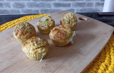 Imagem da receita de Muffin de queijo com brócolis, em uma tábua sobre uma mesa