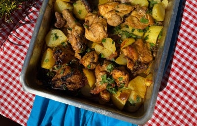 Frango assado dourado com batatas em rodelas levemente crocantes nas bordas, tudo coberto com cebolas caramelizadas e cheiro-verde fresco. Servido em assadeira rústica sobre mesa de madeira. Frango assado dourado com batatas em rodelas levemente crocantes nas bordas, tudo coberto com cebolas caramelizadas e cheiro-verde fresco. Servido em assadeira rústica sobre mesa de madeira.