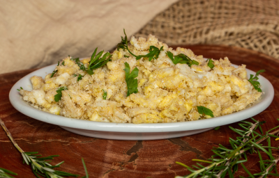 Fotografia em tons de amarelo com um prato branco ao centro. Em cima do prato existe uma receita de farofa de ovos feita com farinha de mandioca e finalizada com cheiro-verde. Fotografia em tons de amarelo com um prato branco ao centro. Em cima do prato existe uma receita de farofa de ovos feita com farinha de mandioca e finalizada com cheiro-verde.