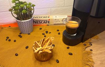 Fotografia em tons de laranja com uma cafeteira ao centro. Ao lado da cafeteira existe um pote com casca de laranjas cristalizadas.