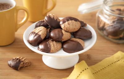 Foto da receita de Biscoitinho de Cappuccino. Observa-se uma boleira branca com 8 biscoitinhos em cima, banhados pela metade com chocolate.