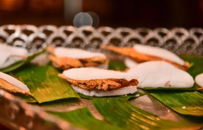 Foto da receita de Ginga com Tapioca. Observa-se algumas tapiocas recheadas de peixe empanado sobre folhas de bananeira.