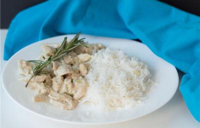 A imagem mostra um prato montado com arroz e tiras de frango com molho, decorado com alecrim A imagem mostra um prato montado com arroz e tiras de frango com molho, decorado com alecrim