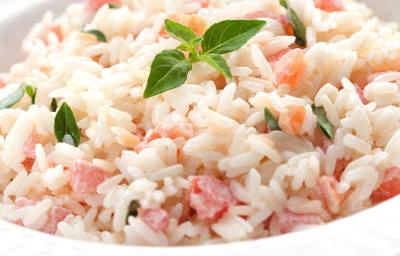 foto em tons de branco e vermelho tirada de um prato redondo branco com arroz e tomate