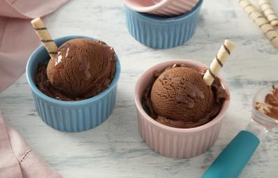 Foto da receita de MOÇA Sorvete com Nescau. Observa-se dois potinhos individuais, um rosa e um azul, um com cada bola de sorvete. Cada potinho tem um palito de wafer.