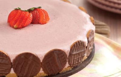 fotografia em tons de rosa e marrom tirada de uma torta de morango com biscoitos de chocolates em volta