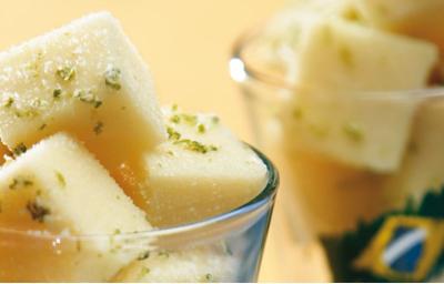 em dois copos transparentes contém cubos de gelatina com raspas de limão. No segundo copo ao fundo contém a foto da bandeira do Brasil.