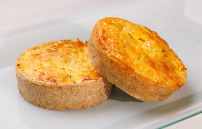 Fotografia de dois salgados assados feitos com massa podre e recheio cremoso de Requeijão NESTLÉ, champignon e cebolinha.