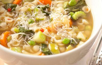 foto tirada de um recipiente branco e redondo com a sopa que contém pedaços de cenoura e chuchu.