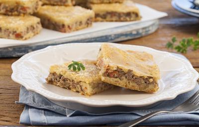 Foto de um prato branco com dois pedaços de torta de carne moída dentro.