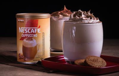 Foto da receita de cappuccino super cremoso servida em dois copos de vidro sobre uma louça vermelha em cima de uma mesa de madeira Foto da receita de cappuccino super cremoso servida em dois copos de vidro sobre uma louça vermelha em cima de uma mesa de madeira