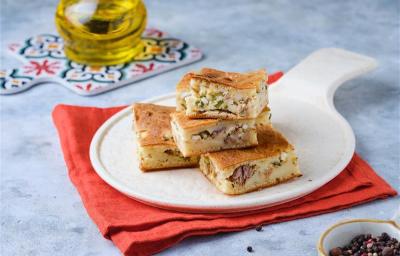 Fotografia mostra pedaços de torta de sardinha sobre um prato branco.