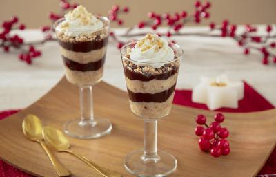 Fotografia de taças individuais mostrano camadas de creme de paçoca, chocolate e no topo chantilly com pedaços de paçoca triturado.