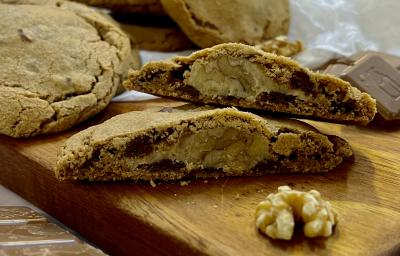 Foto da receita de Cookies recheados de nozes. Na foto observa-se cookies dispostos sobre uma tábua de madeira.