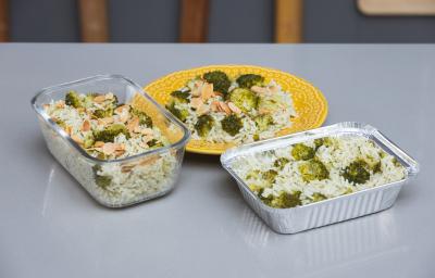 Foto da receita de Arroz com Brócolis em uma vasilha de vidro, uma forma de alumínio e sobre um prato amarelo, em cima de uma bancada