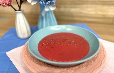 Fotografia em tons de rosa e azul com um prato azul ao centro. Dentro do prato existe uma receita de sopa de legumes com ASCENDA