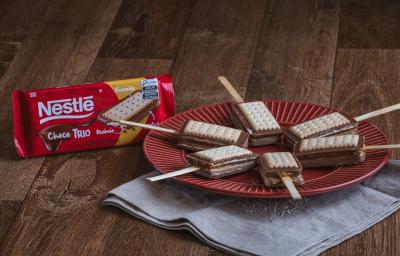 Foto da receita de    Receita de Pirulito de Paçoca com Choco Trio Amendoim. Observa-se 6 pirulitos dispostos em um prato vermelho redondo sobre um pano cinza.