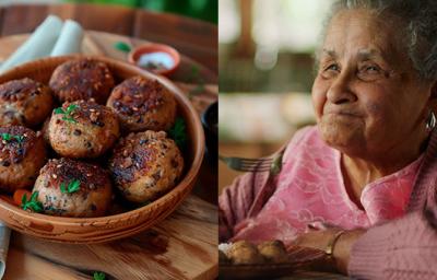 Foto dividia ao meio. Do lado esquerdo está uma tigela de madeira contendo a receita de Bolinhos de Feijão e ao lado direito uma senhora com blusa rosa experimentando um pedaço com um sorriso no rosto