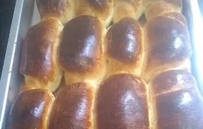 Foto da receita de Pão Sem Lactose. Observa-se um recipiente refratário preenchido de pães assados e dourados.