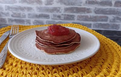 Imagem Imagem da receita de Panqueca Americana nutritiva com cobertura de geleia de frutas, em um prato branco, e ao lado os talheres