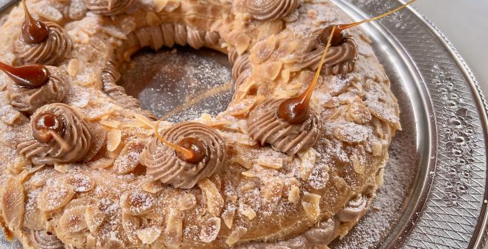 Foto da Receita de Paris Brest com Creme Mousseline, delicioso e impressionante, feito com uma base de massa choux tradicional e um recheio de creme mousseline com pasta de avelã, decorado com açúcar polvilhado e pontos e caramelo