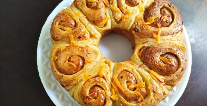 Foto da Receita de Pão de Rosas. Observa-se um pão com formato de rosas brilhante.