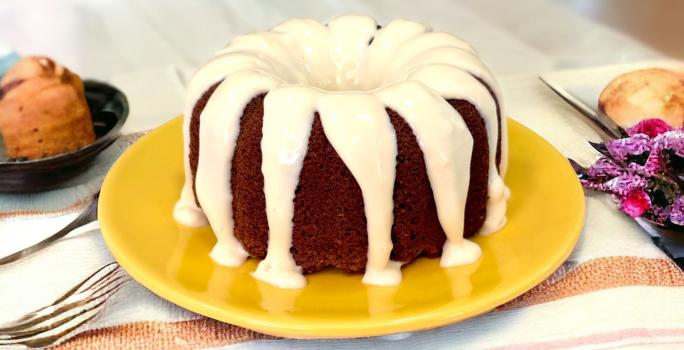 Fotografia em tons de amarelo com um prato amarelo ao centro. Em cima do prato existe um bolo de chocolate com cobetura de Ninho.