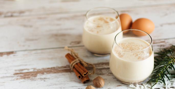 Receita de Gemada Clássica de Natal e Ano Novo, tradicional e deliciosa, feita com ovos, fava de baunilha, NESTLÉ Creme de Leite, Leite Líquido NINHO Forti+ Integral, conhaque e canela, servido em copinhos numa bancada de madeira