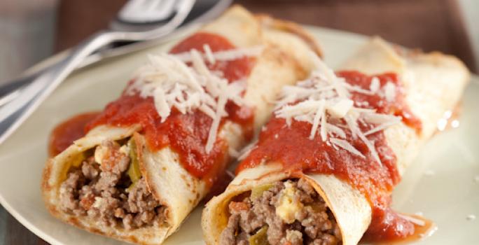 Foto de duas panquecas de carne moída cobertas com molho de tomate e queijo em um prato branco em cima de um pano marrom